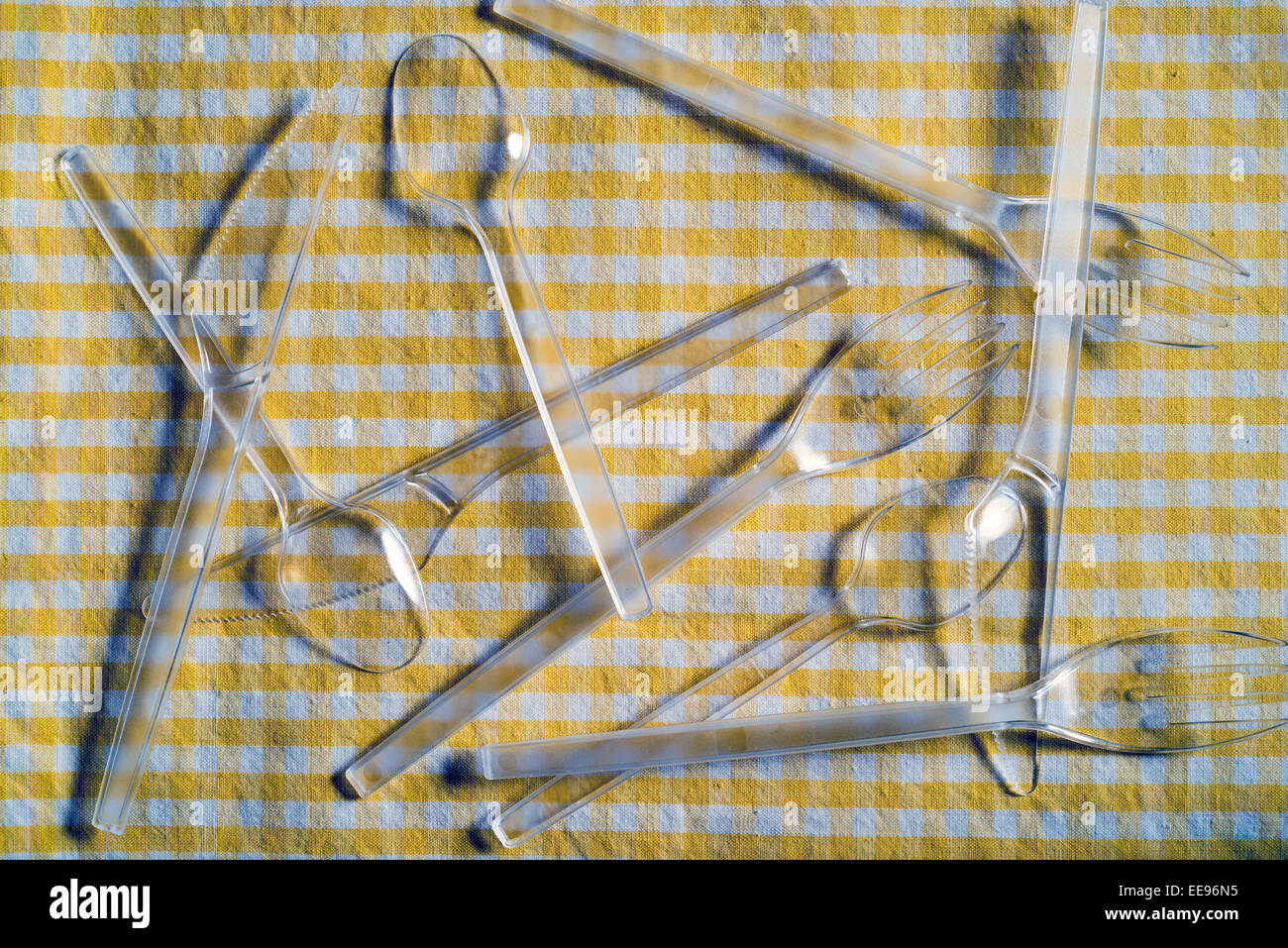 plastic cutlery on a checkered tablecloth Stock Photo