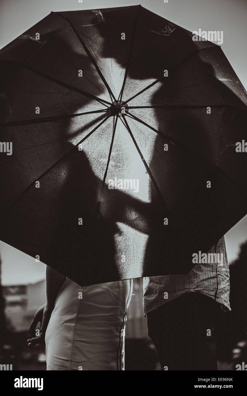 Love in the rain / Silhouette of kissing couple under umbrella Stock ...