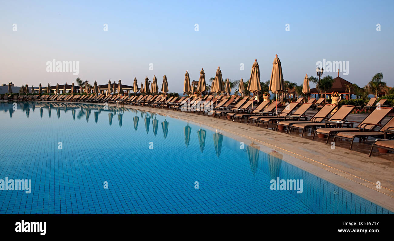 Chaise longue and umbrellas near the pool Stock Photo - Alamy