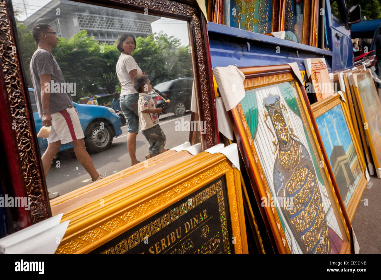 People passing through a mirror and house decoration vendor in Surabaya, East Java, Indonesia. Stock Photo
