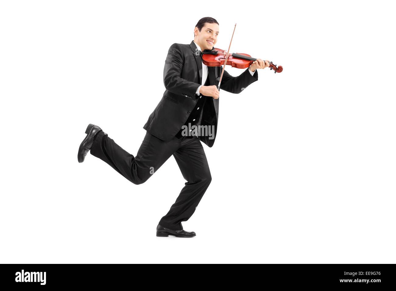 Full length portrait of a man running and playing a violin isolated on white background Stock Photo