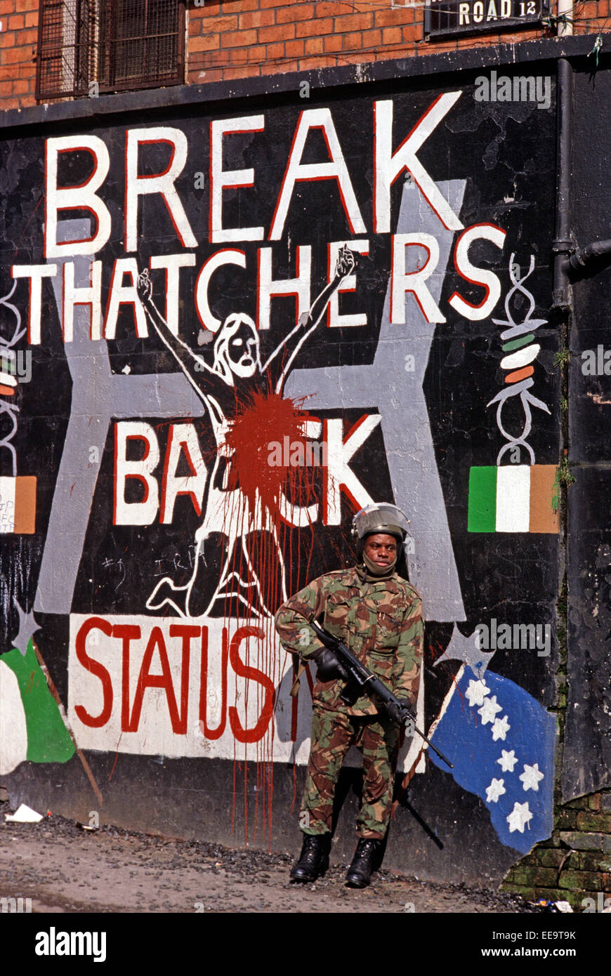 BELFAST NORTHERN IRELAND - October 1982; British Army Soldier standing in front of Republican Mural depicting Margaret Thatcher's stand against the Republican Hunger Strikers in the Maze Prison. Stock Photo