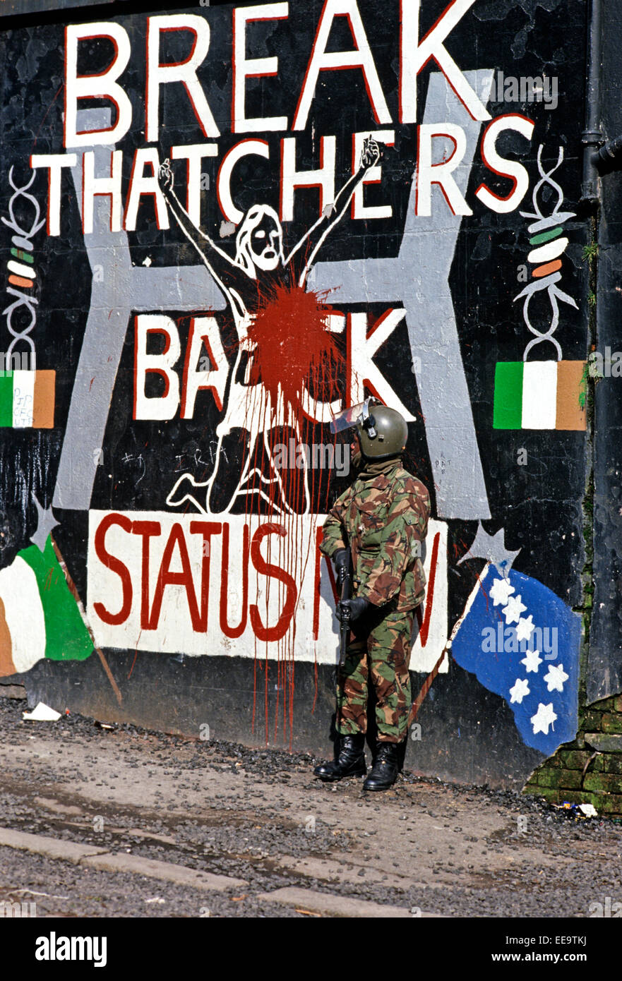 BELFAST, NORTHERN IRELAND - October 1982; British Army Soldier standing in front of Republican Mural depicting Margaret Thatcher's stand against the Republican Hunger Strikers in the Maze Prison. Stock Photo