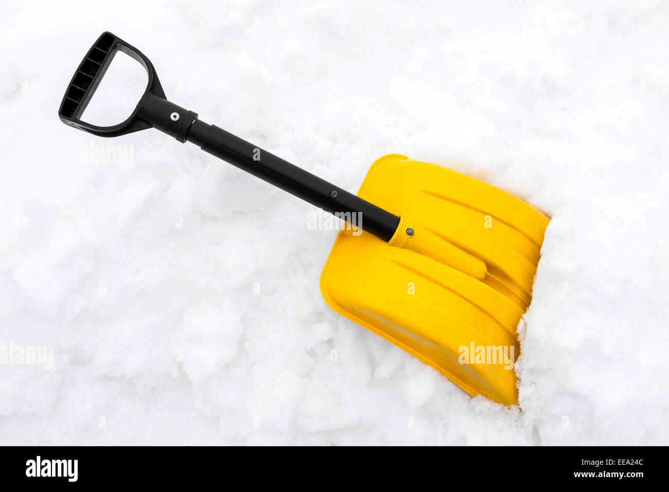 Yellow snow shovel on white snow Stock Photo Alamy
