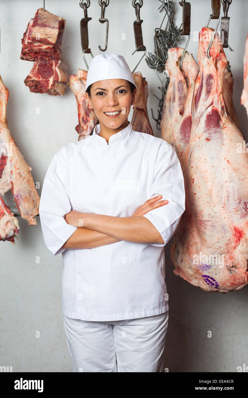 Butcher Standing Against Meat Hanging In Butchery Stock Photo Alamy