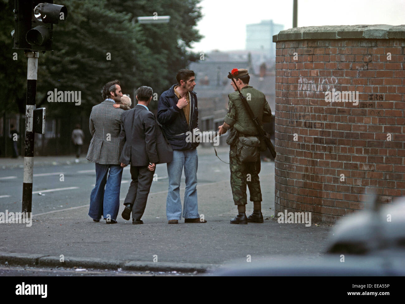 BELFAST, NORTHERN IRELAND - AUGUST 1976. Nationalist being questioned by British Army Soldier during The Troubles, Falls Road, West Belfast, Northern Ireland. Stock Photo