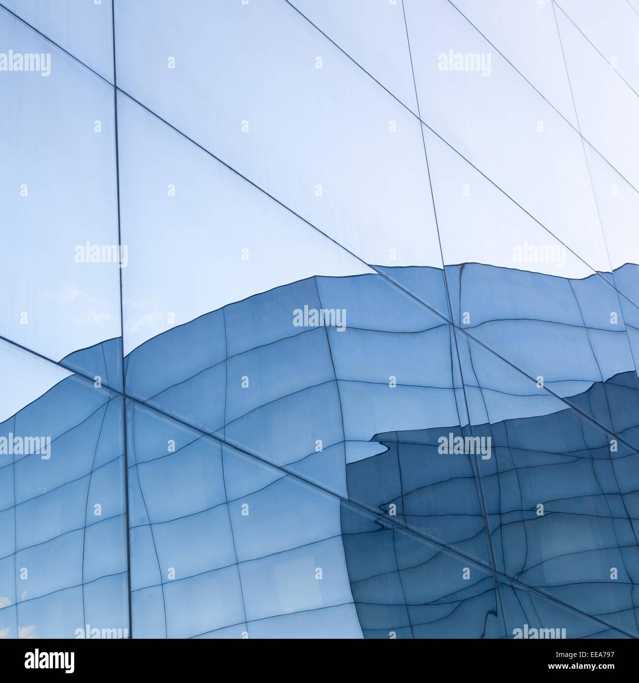 part of geometrically shaped modern glass building with reflections of ...