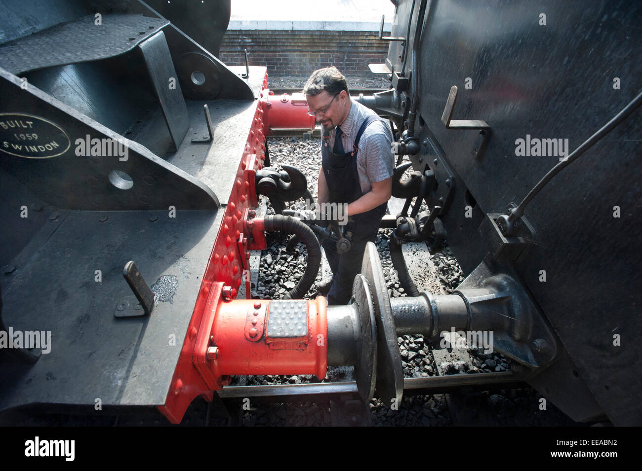 The fireman of 9F 2-10-0 Steam Locomotive number 92203 'Black Prince' uncouples the Engine from its coaches before it runs round its train at Sheringham station on the North Norfolk Railway near Norwich, Norfolk, England, Britain, UK . Animal and Railway Artist David Shepherd restored the Steam Engine to working order Stock Photo