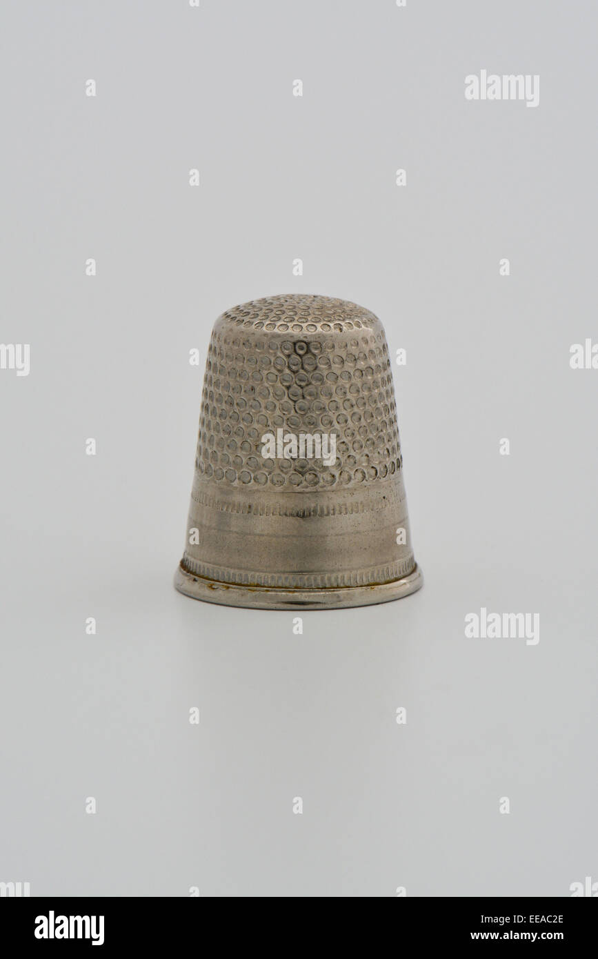 close up of silver metal thimble against white background Stock Photo