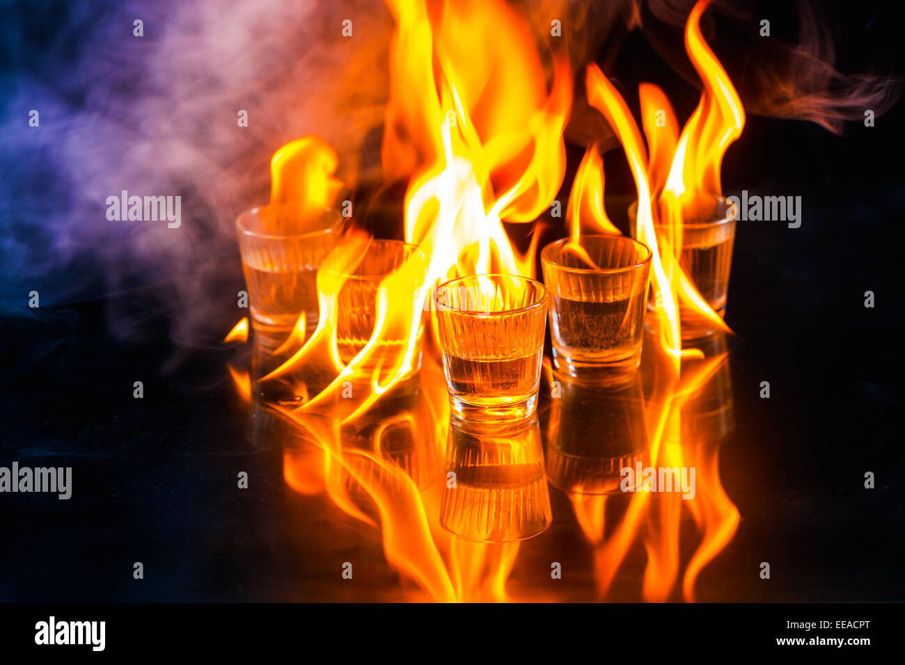 Glasses with burning alcohol on black background Stock Photo - Alamy