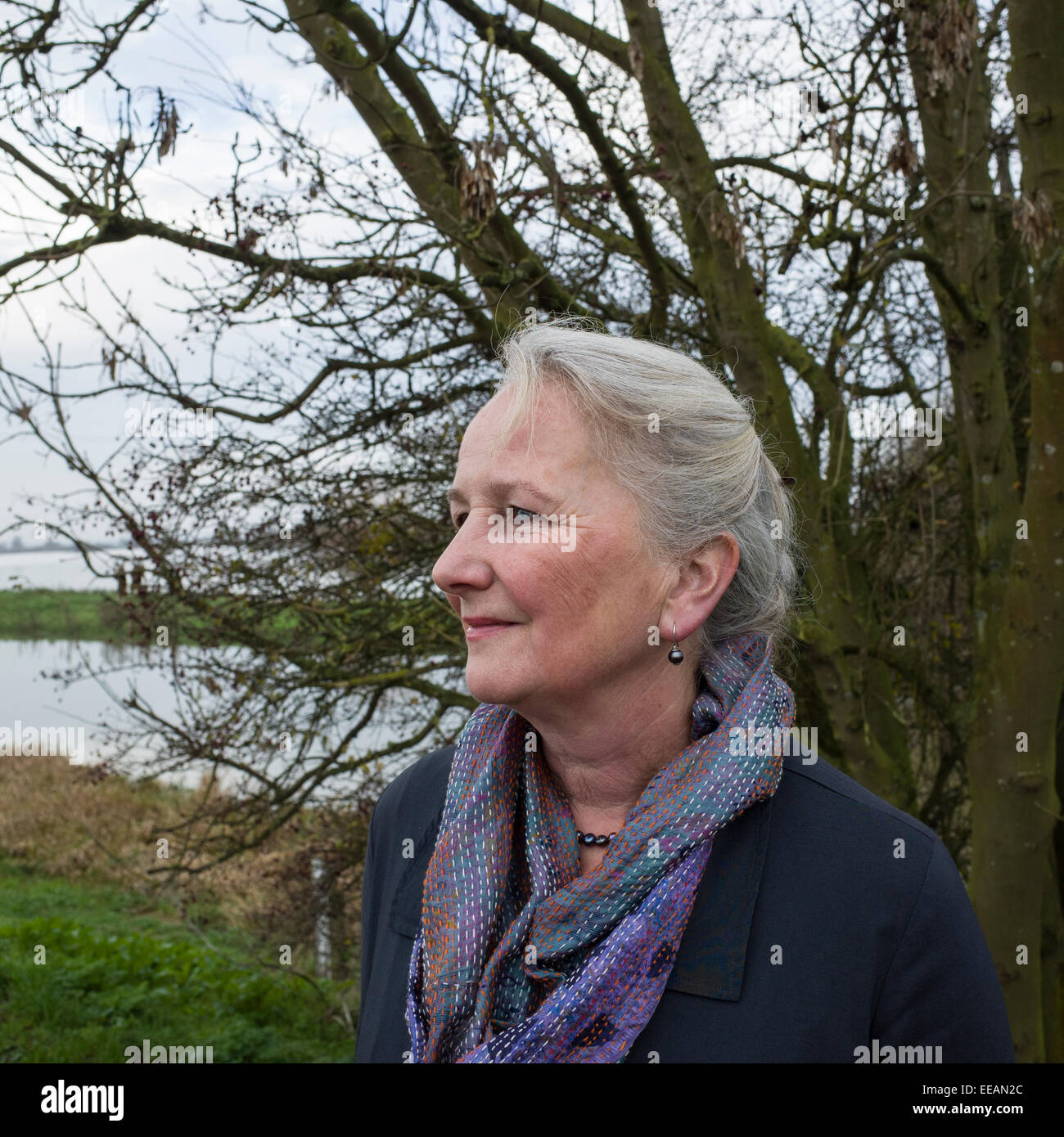 Outdoor Portrait of a Senior Woman with Winter Tree Branches Stock Photo