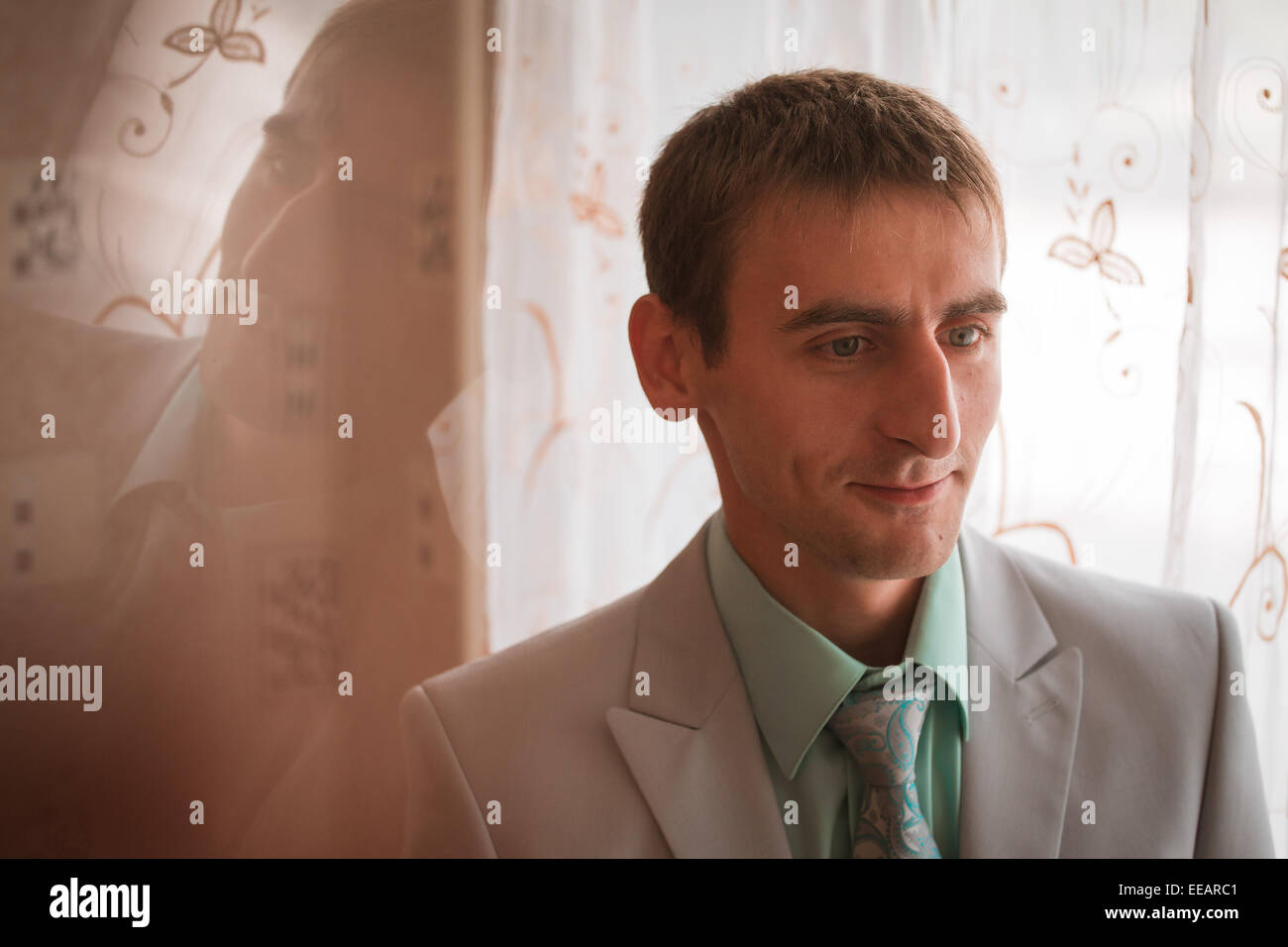 View of Portrait of young groom tying tie while getting ready for wedding Stock ...