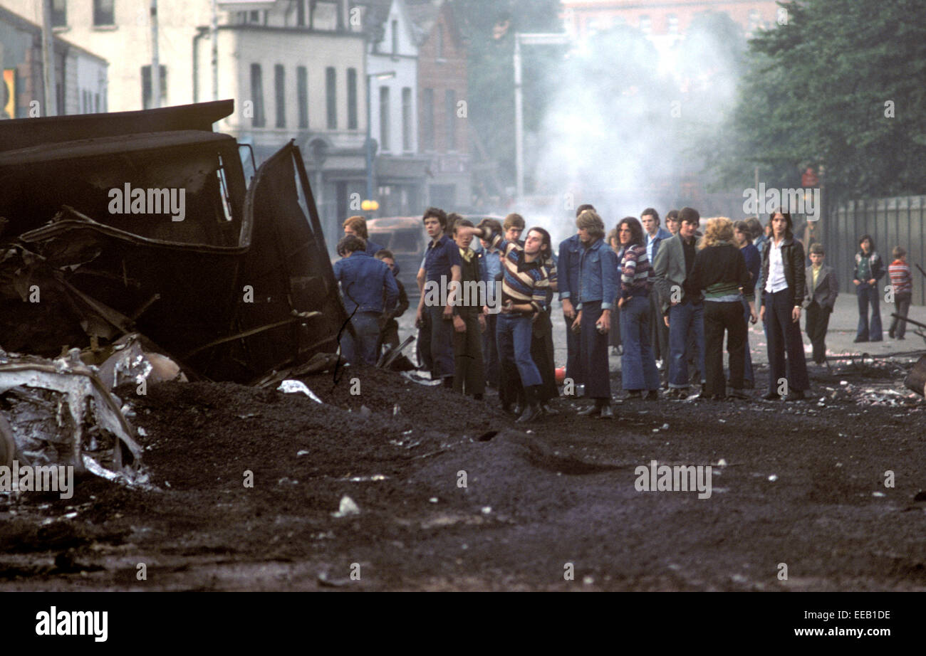 BELFAST, NORTHERN IRELAND - AUGUST 1976. Nationalist Youths throwing stones at the British Army during Riots in the Falls Road, West Belfast during The Troubles, Northern Ireland. Stock Photo