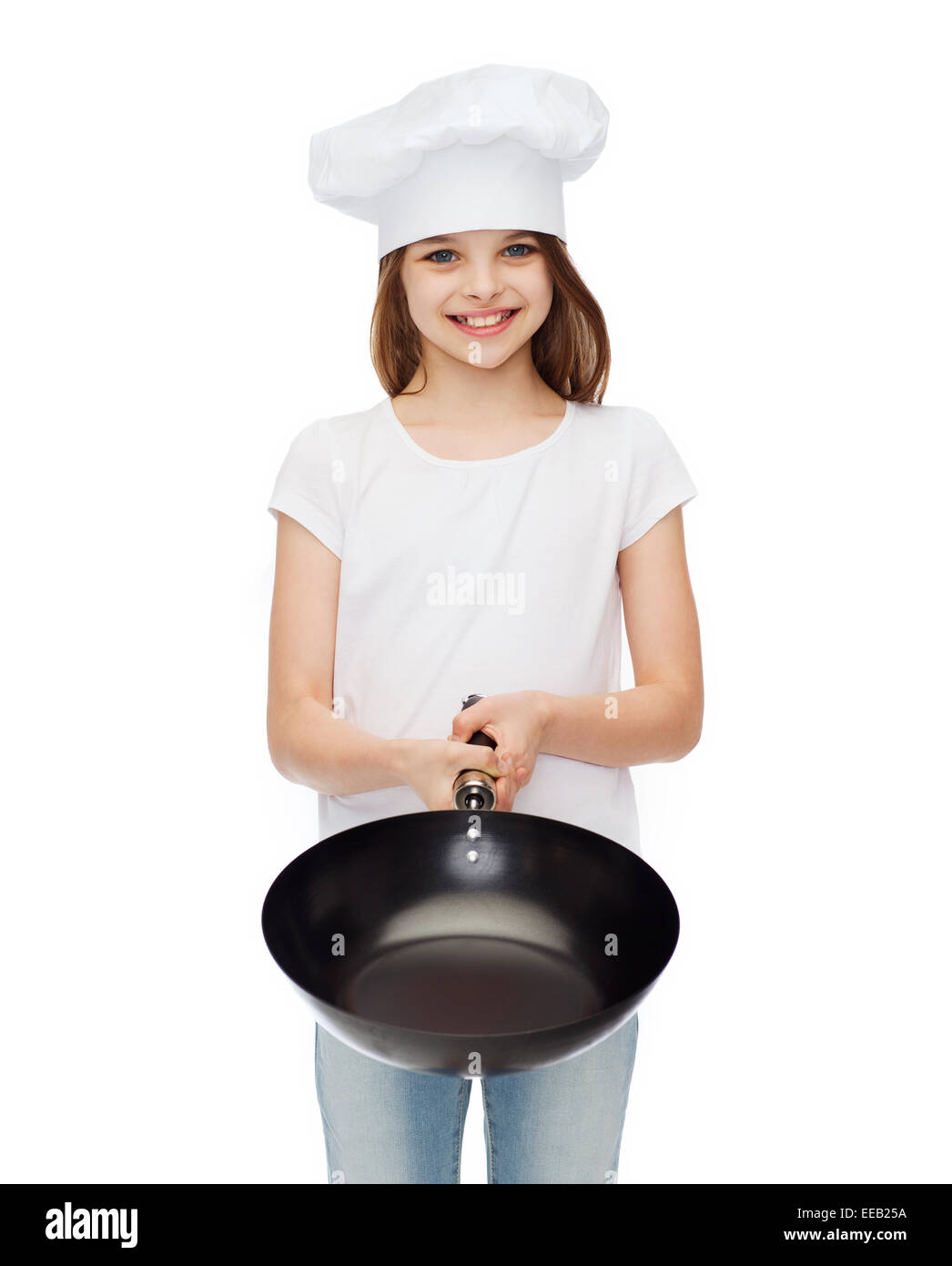 smiling girl in cook hat giving frying pan Stock Photo