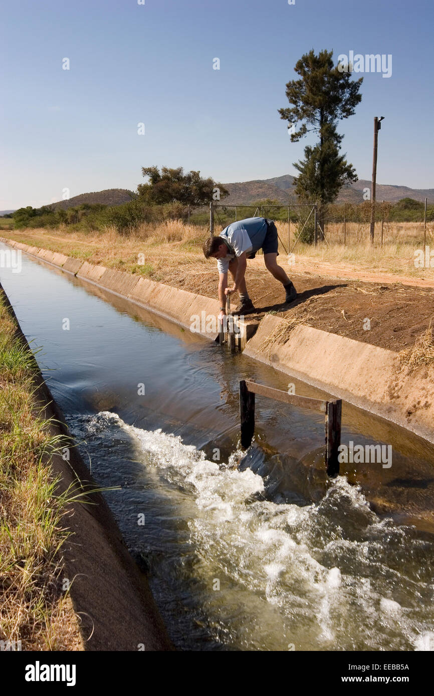 Adjusting canal sluice gate with water supply for local community and nearby platinum mine from Olifants River as source. Stock Photo