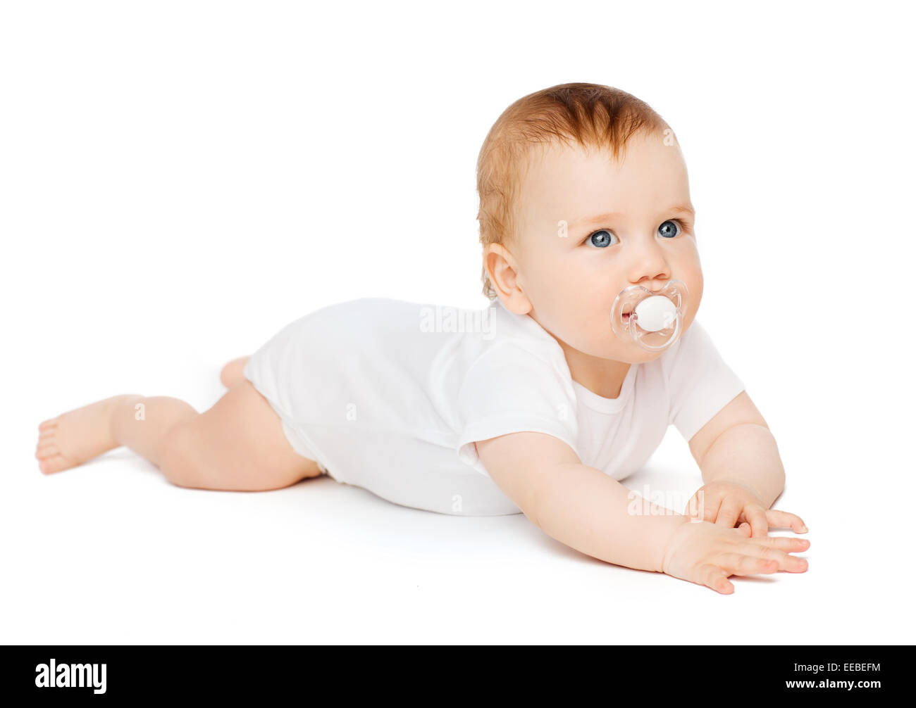 smiling baby lying on floor with dummy in mouth Stock Photo