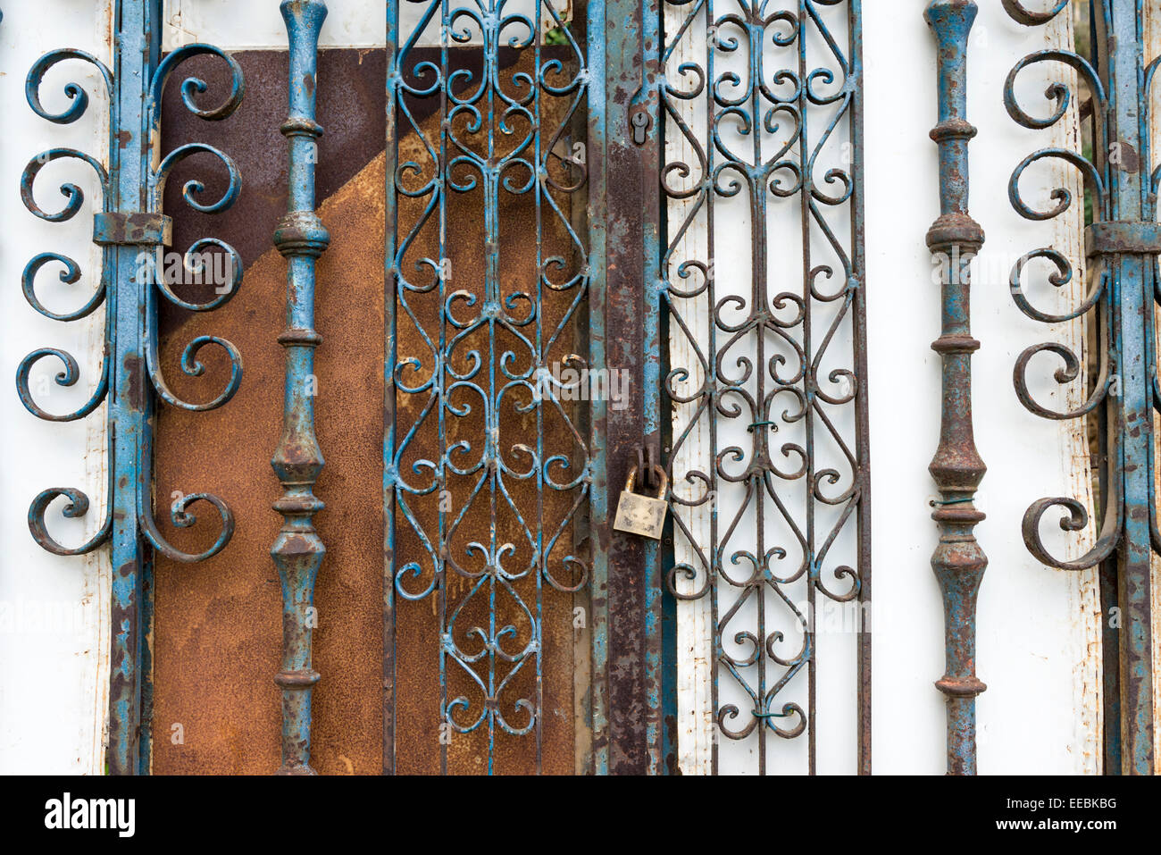 Rusty wrought iron gates on a rundown doorway on an old building Stock