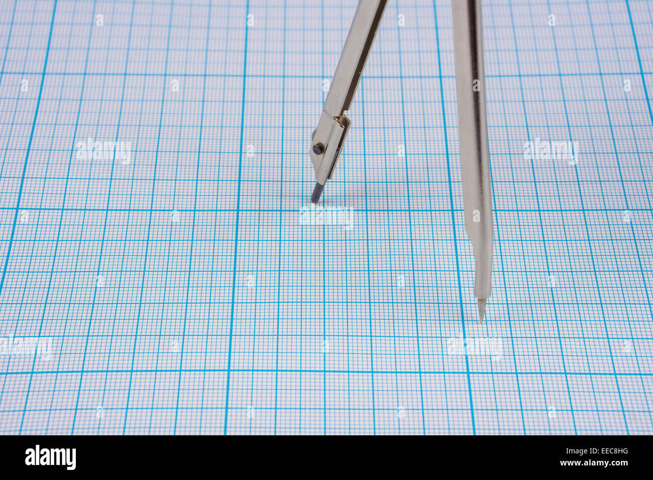 Compasses legs on graph paper background Stock Photo