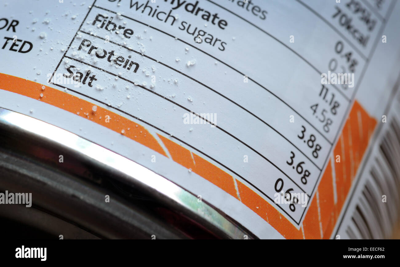 FOOD TIN CONTENTS LABEL WITH SALT GRAINS RE FAT FIBRE PROTEIN OBESITY CRISIS HIGH BLOOD PRESSURE GUIDELINE AMOUNT CALORIES UK Stock Photo