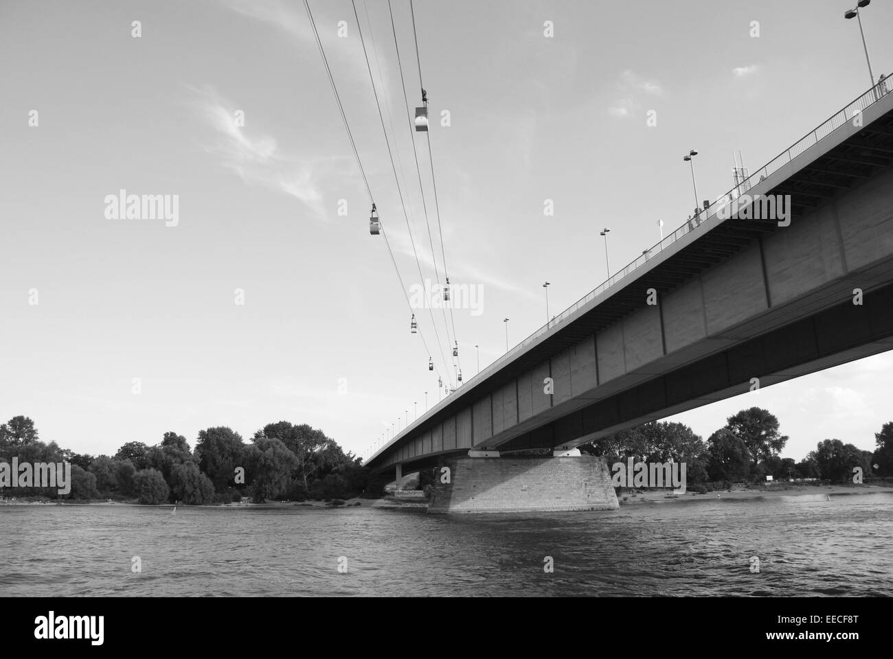 Cable cars cross the Rhine by the Zoobruecke (Zoo Bridge) in Cologne, Germany - monochrome processing Stock Photo