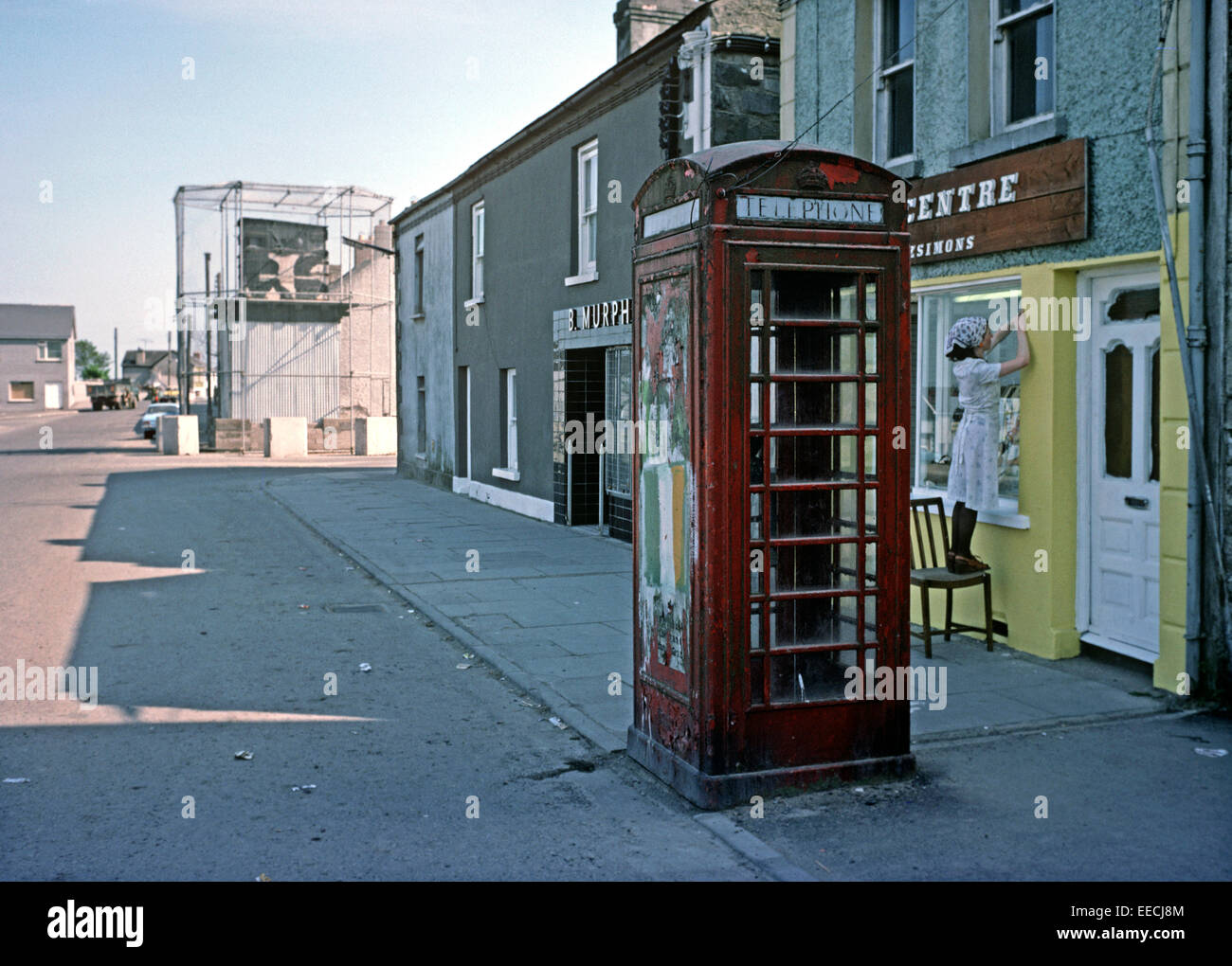 CROSSMAGLEN, NORTHERN IRELAND, JUNE 1977. British Red Telephone Box with the Republic of Ireland Flag painted on in Crossmaglen, South Armagh during The Troubles, Northern Ireland. Stock Photo