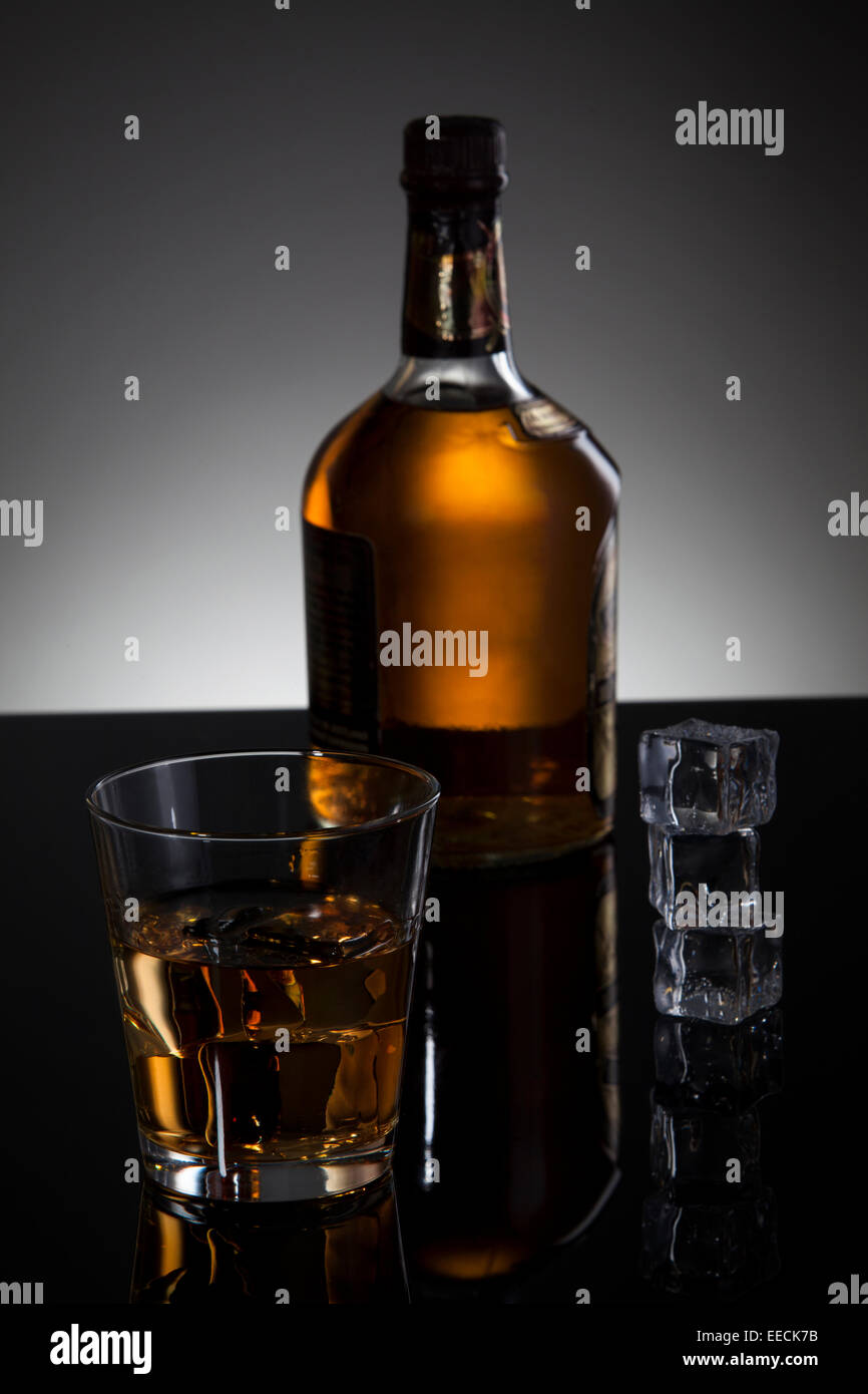 Whiskey bottle and Glass on the dark background Stock Photo - Alamy