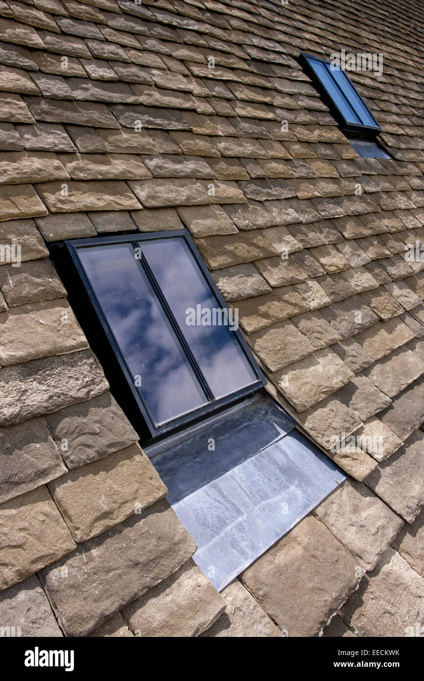 Reproduction Cotswold roof slates and new conservation rooflight window on a Cotswolds stone cottage, Oxfordshire, UK Stock Photo