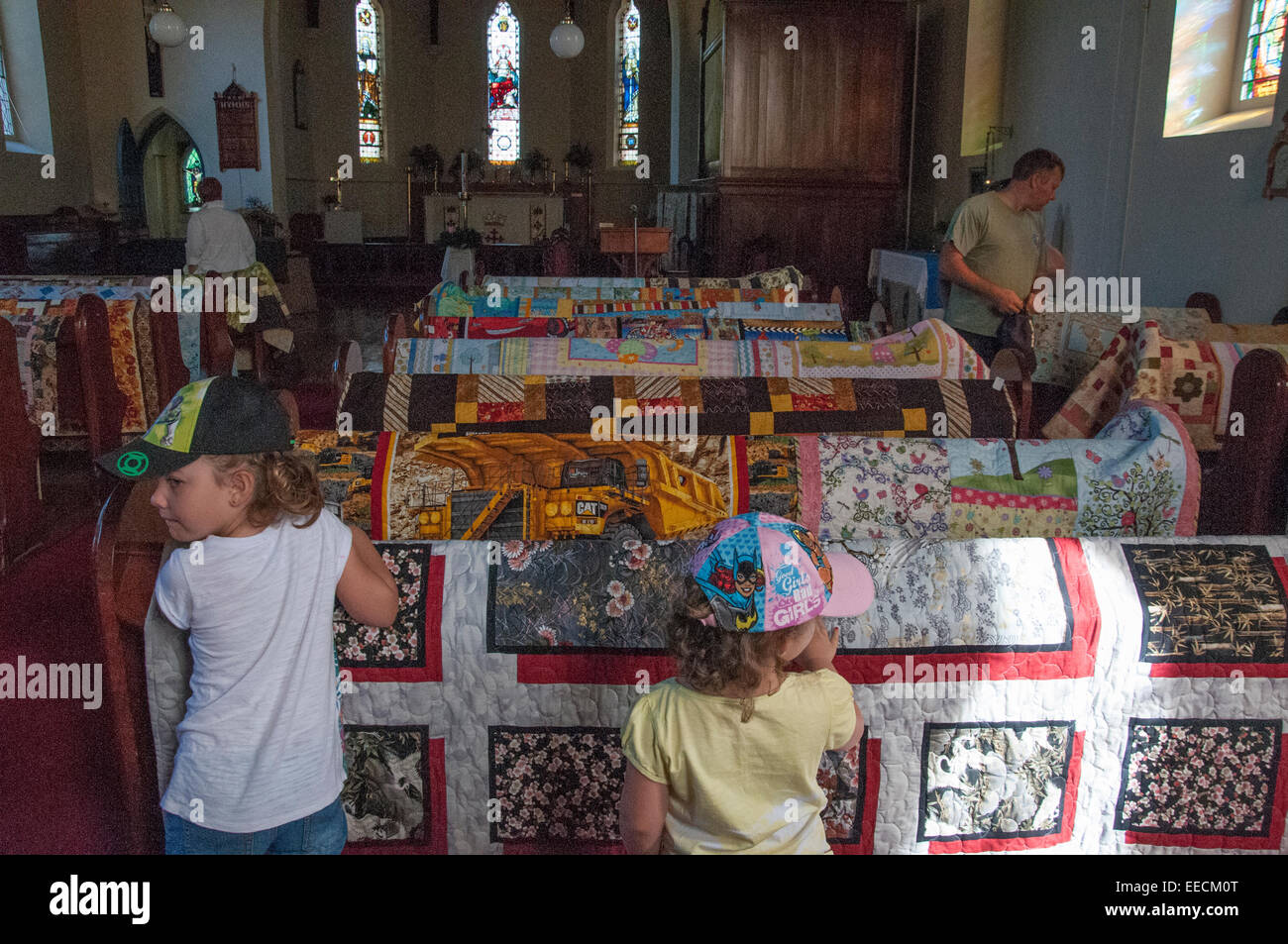 Quilting display at a farmers market at Christ Church, Beechworth, Victoria. The quilts have been spread across church pews. Stock Photo