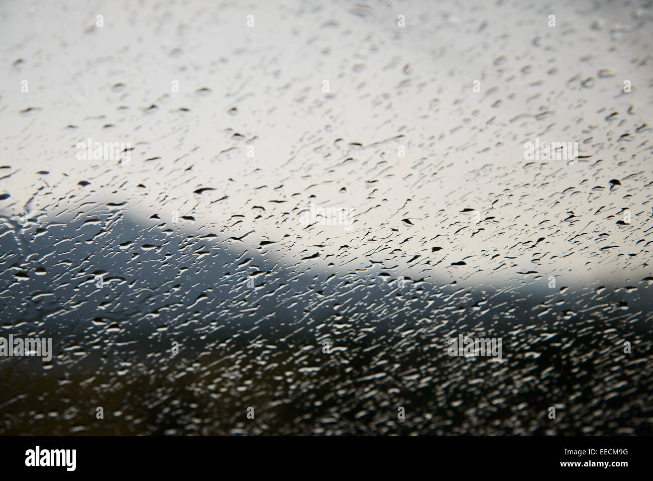 Waterdrops on a window of car with mountain silhouette Stock Photo