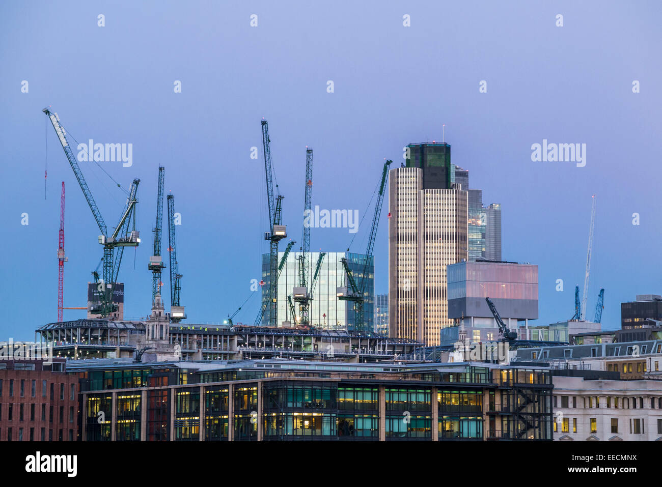 Tower 42 and New Court in the City of London with tower cranes on the site of the new Bloomberg building in London EC4 Stock Photo