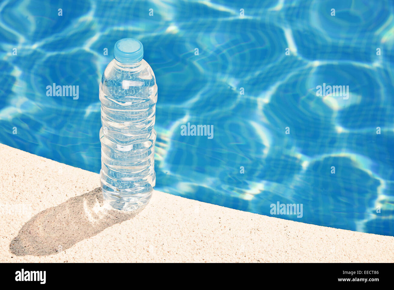 Water bottle by swimming pool Stock Photo