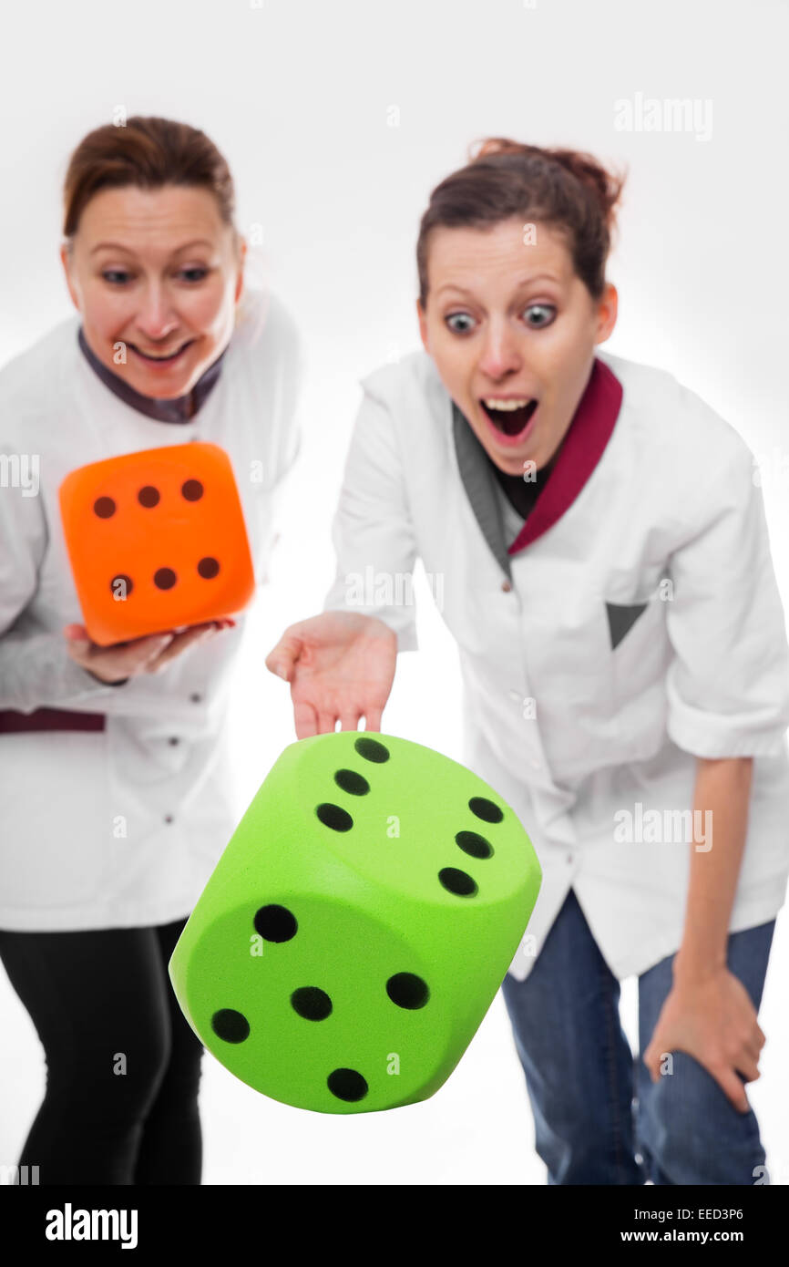 two female nurses rolling dices, room for copy space Stock Photo