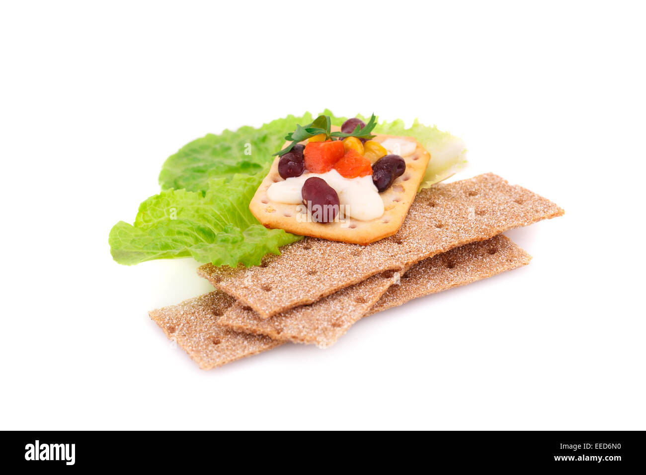 Crackers stacks with fresh vegetables and cream isolated on white ...