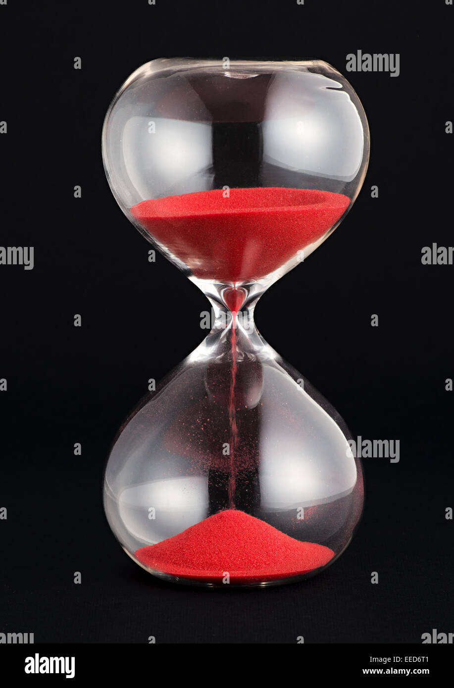 Hourglass with red sand running through the bulbs Stock Photo