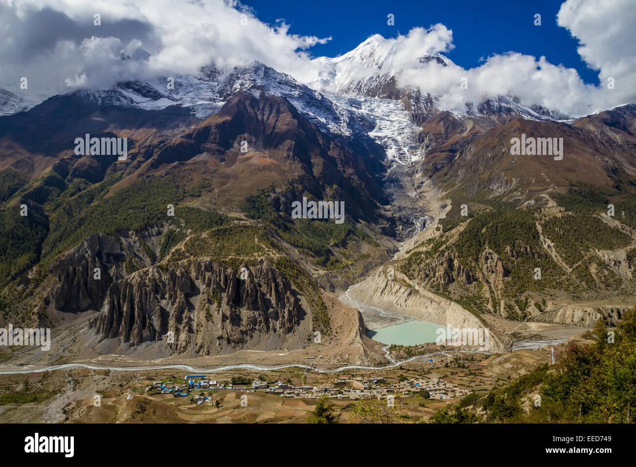 In the Himalayas of Nepal, the peak of Ganga Purna and the Annapurna Mastif loom high over the village of Manang. Stock Photo