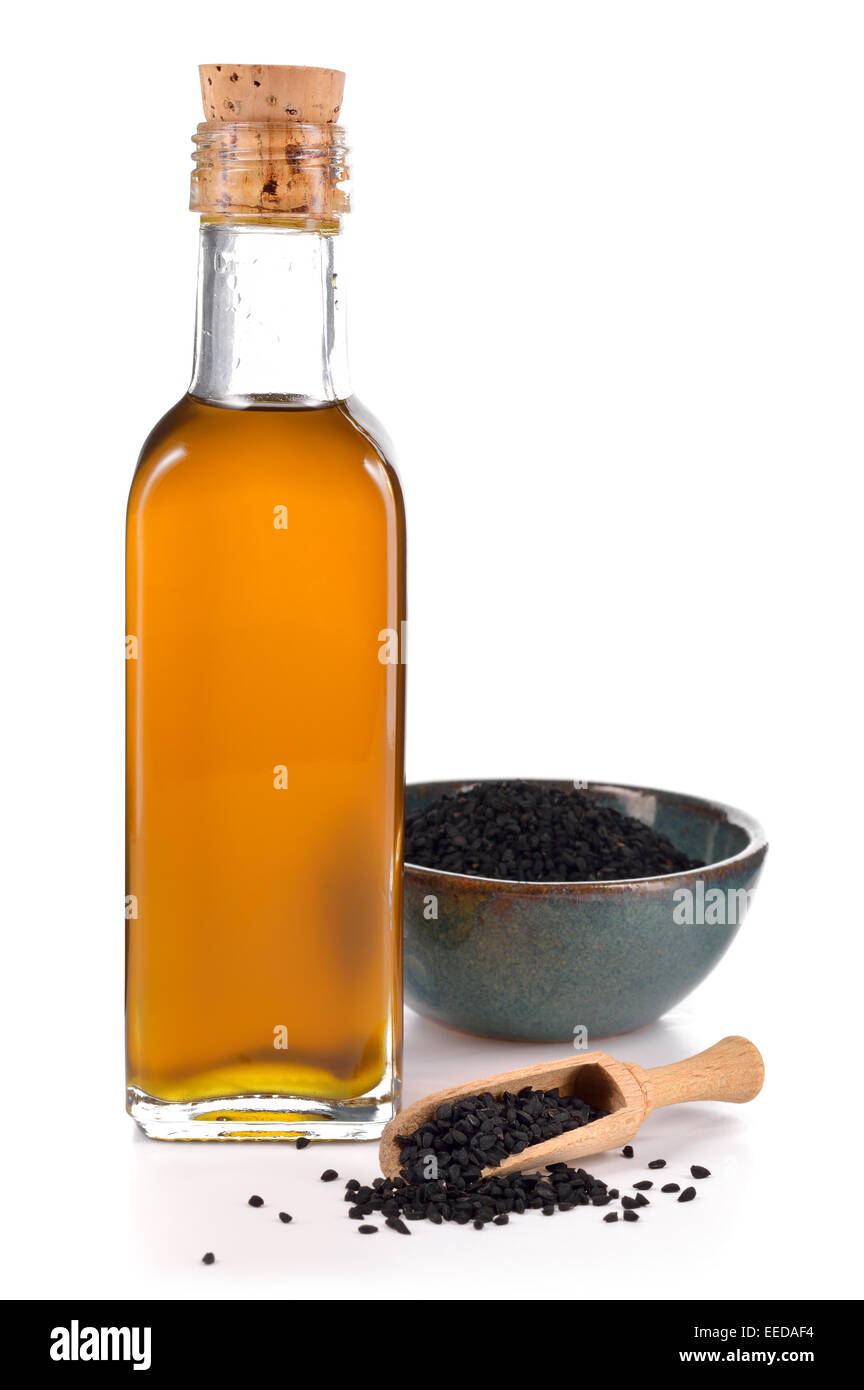 Nigella sativa oil in a bottle and nigella or black cumin seeds in a bowl isolated on white background. Unsaturated fats Omega-6 Stock Photo