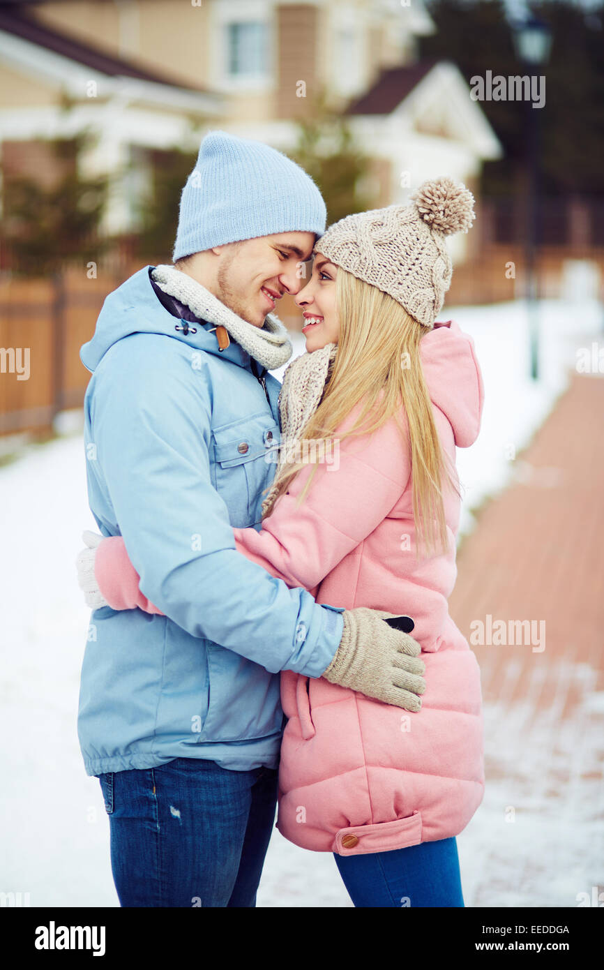 Happy dates in embrace looking at one another outside Stock Photo