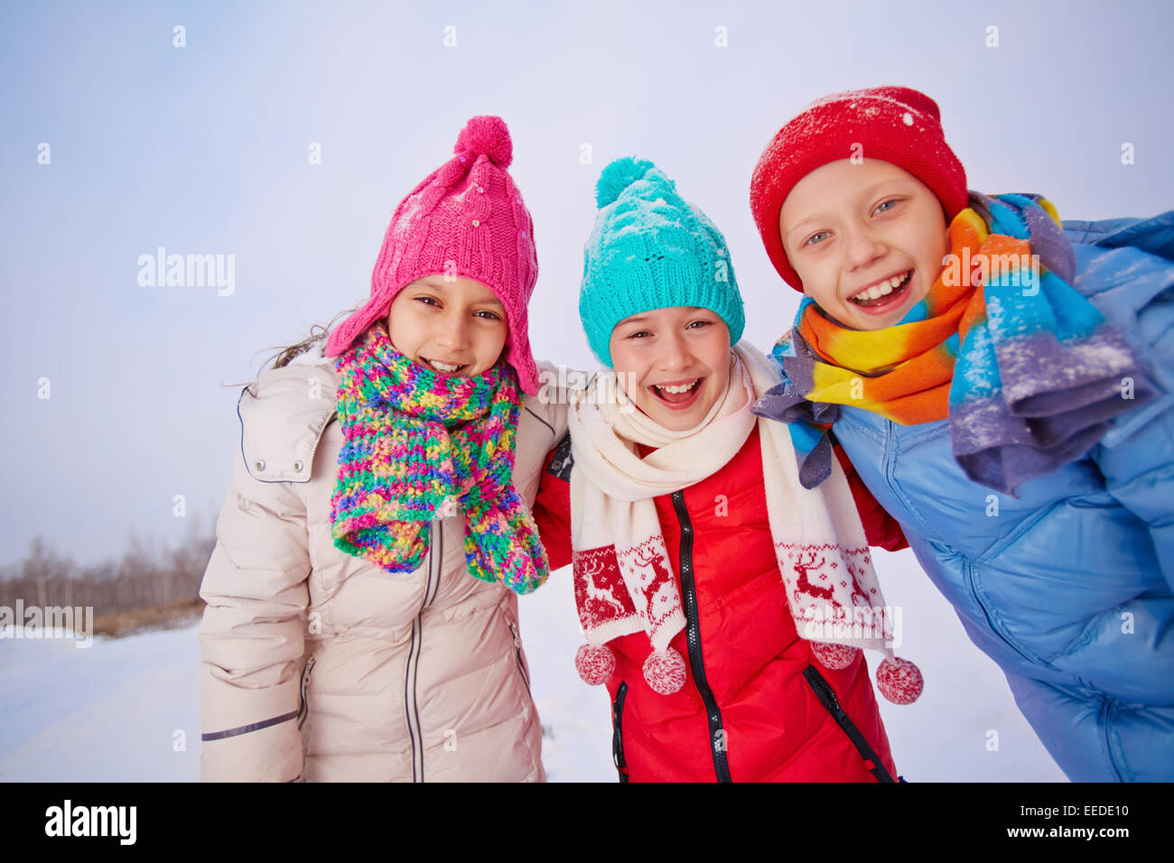 Group of joyful children in winterwear looking at camera Stock Photo ...