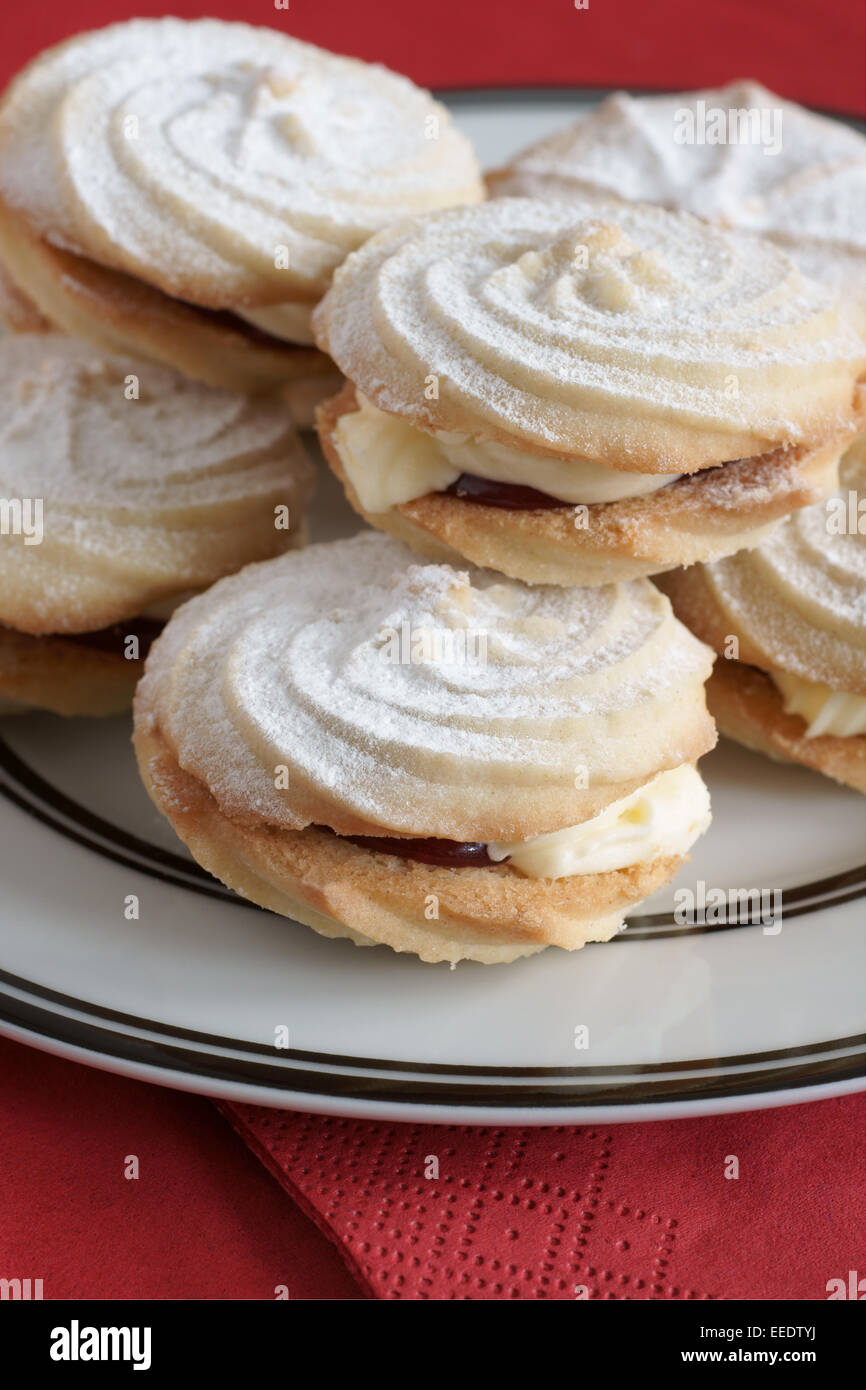 Viennese Whirls a British confection made of a soft butter biscuit piped into a whirl shape filled with buttercream and jam Stock Photo