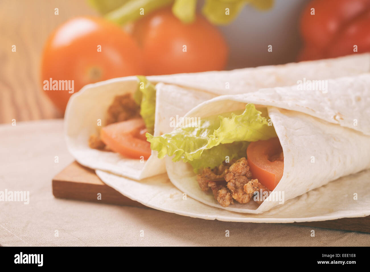 Fresh tortilla wraps with meat and vegetables, vintage toned Stock Photo