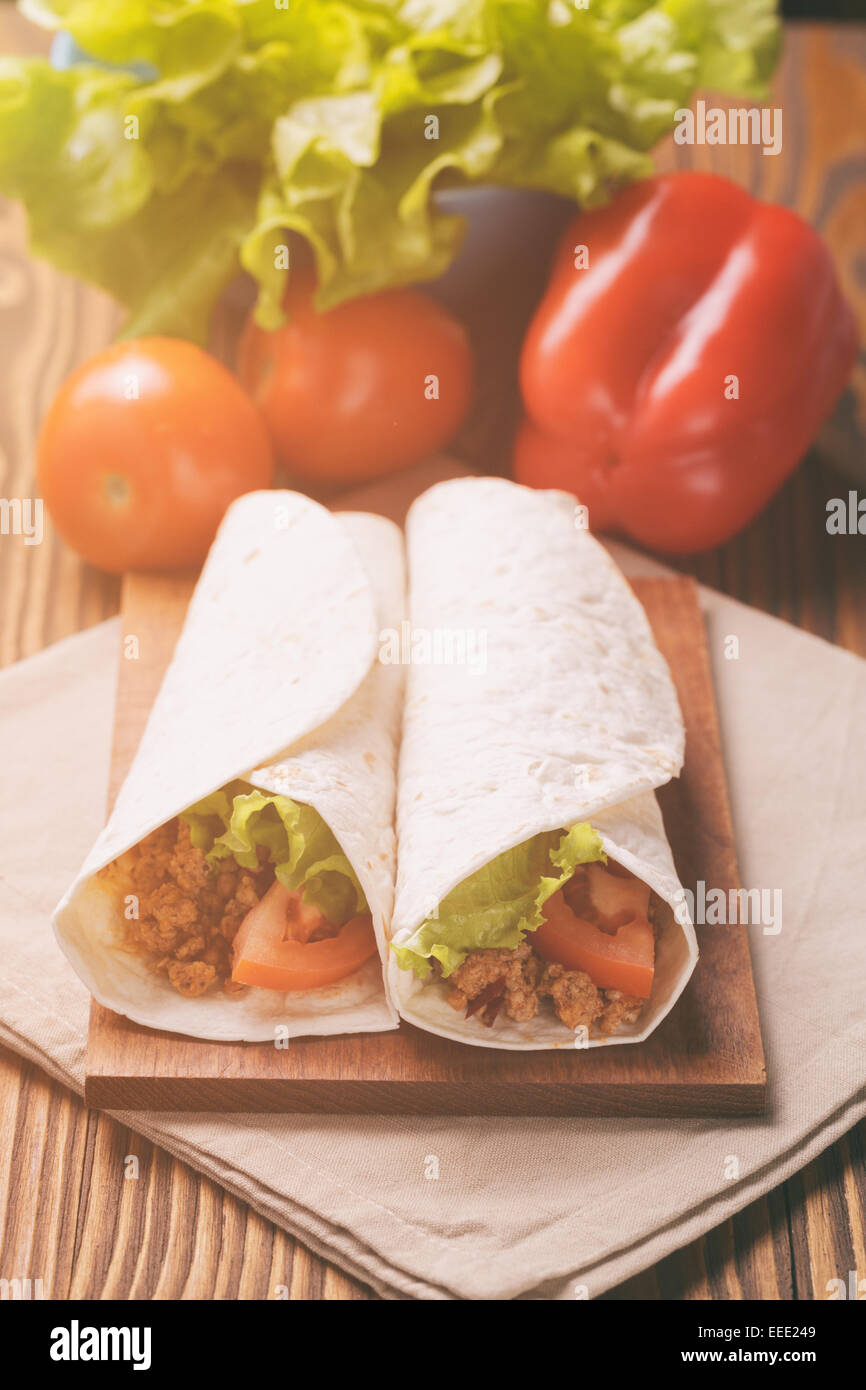 Fresh tortilla wraps with meat and vegetables, vintage toned Stock Photo