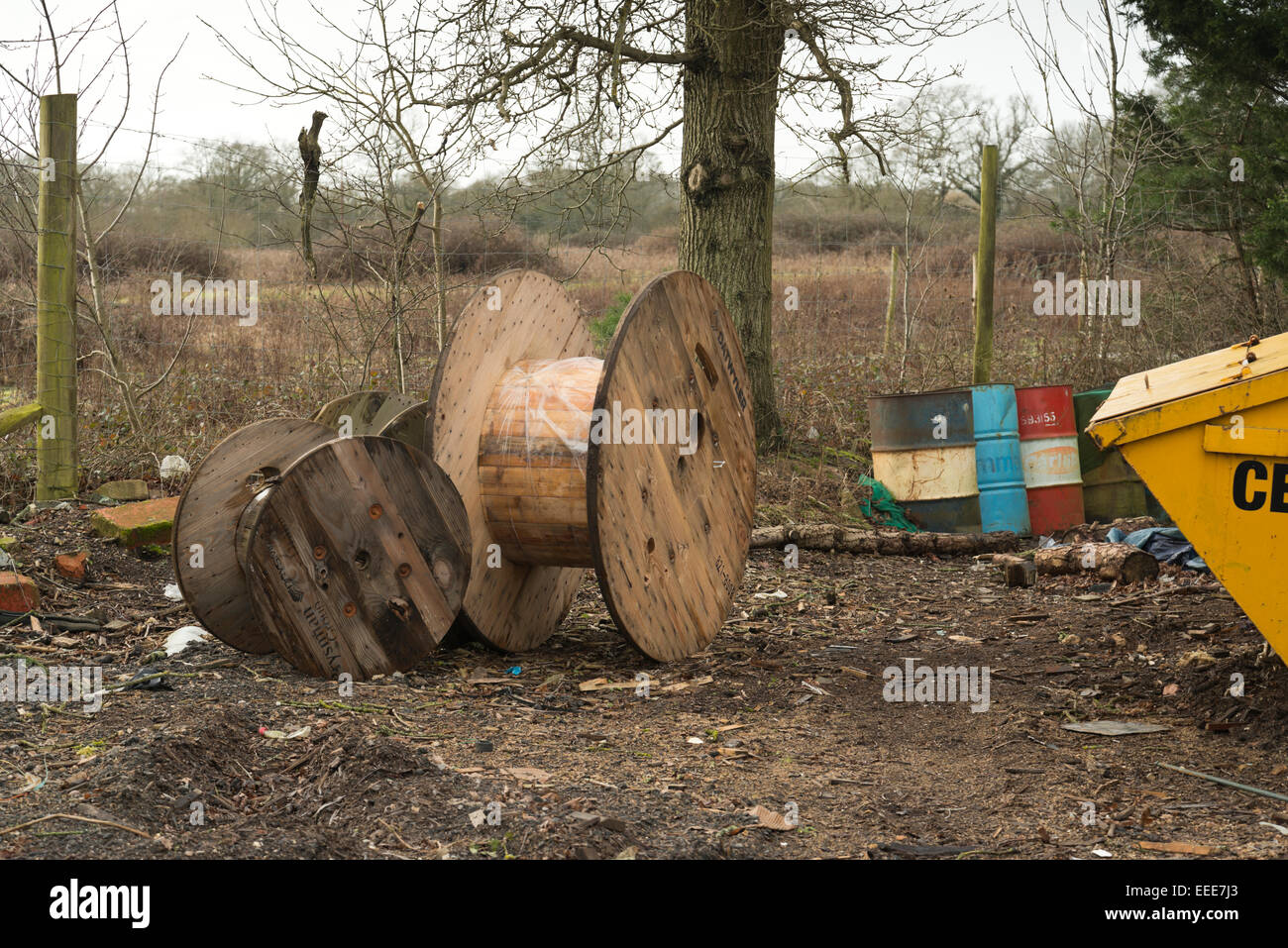 old cable reels & rusty oil drums in a wintry, rubbish strewn landscape. Stock Photo