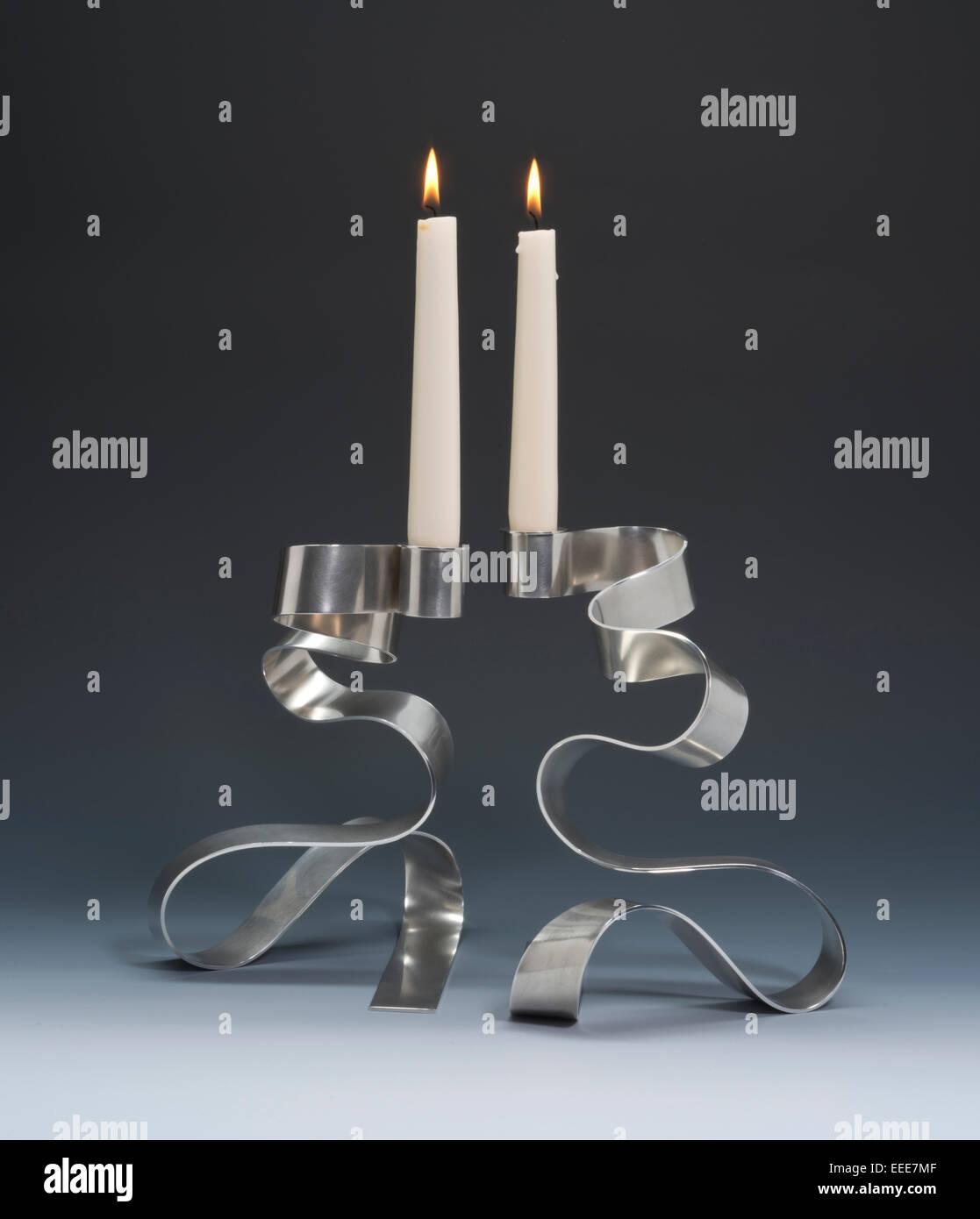 silver candlesticks with lit candles. Stock Photo