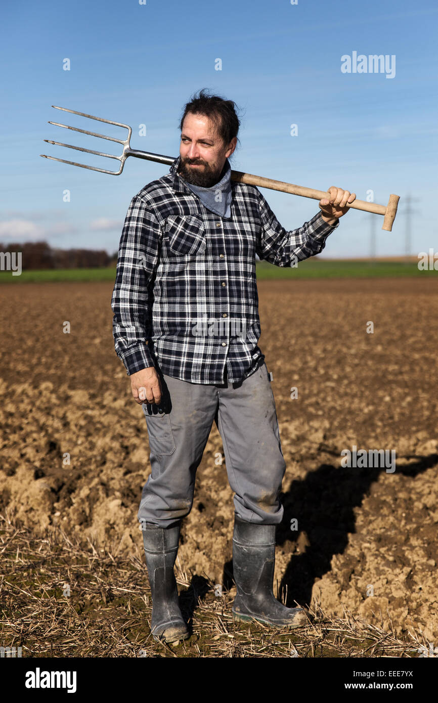 a Portrait of a european Farmer with a pitchfork Stock Photo