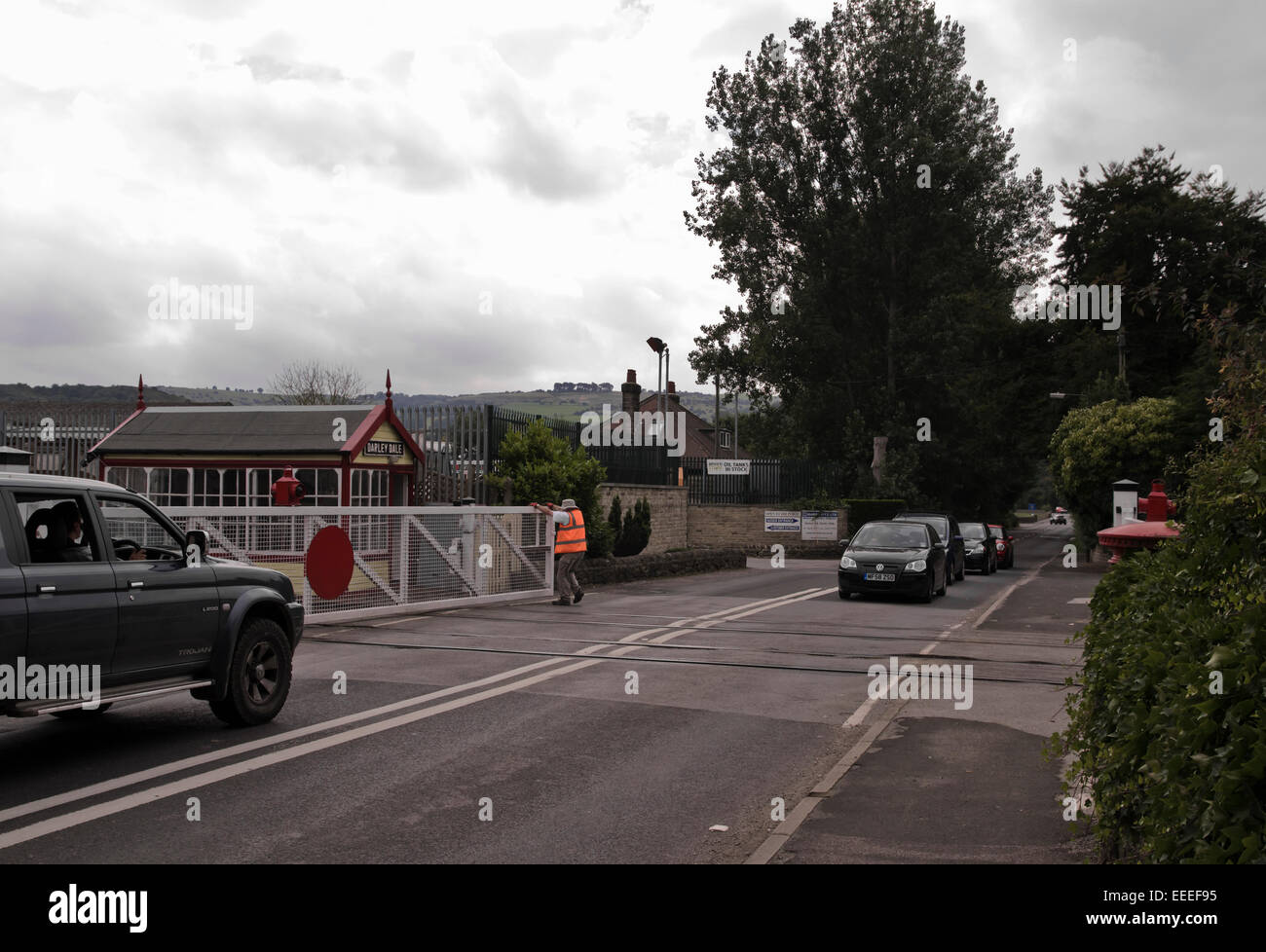 signal man opening / closing gate on level crossing at Darley Dale railway station Peak Rail Derbyshire Stock Photo