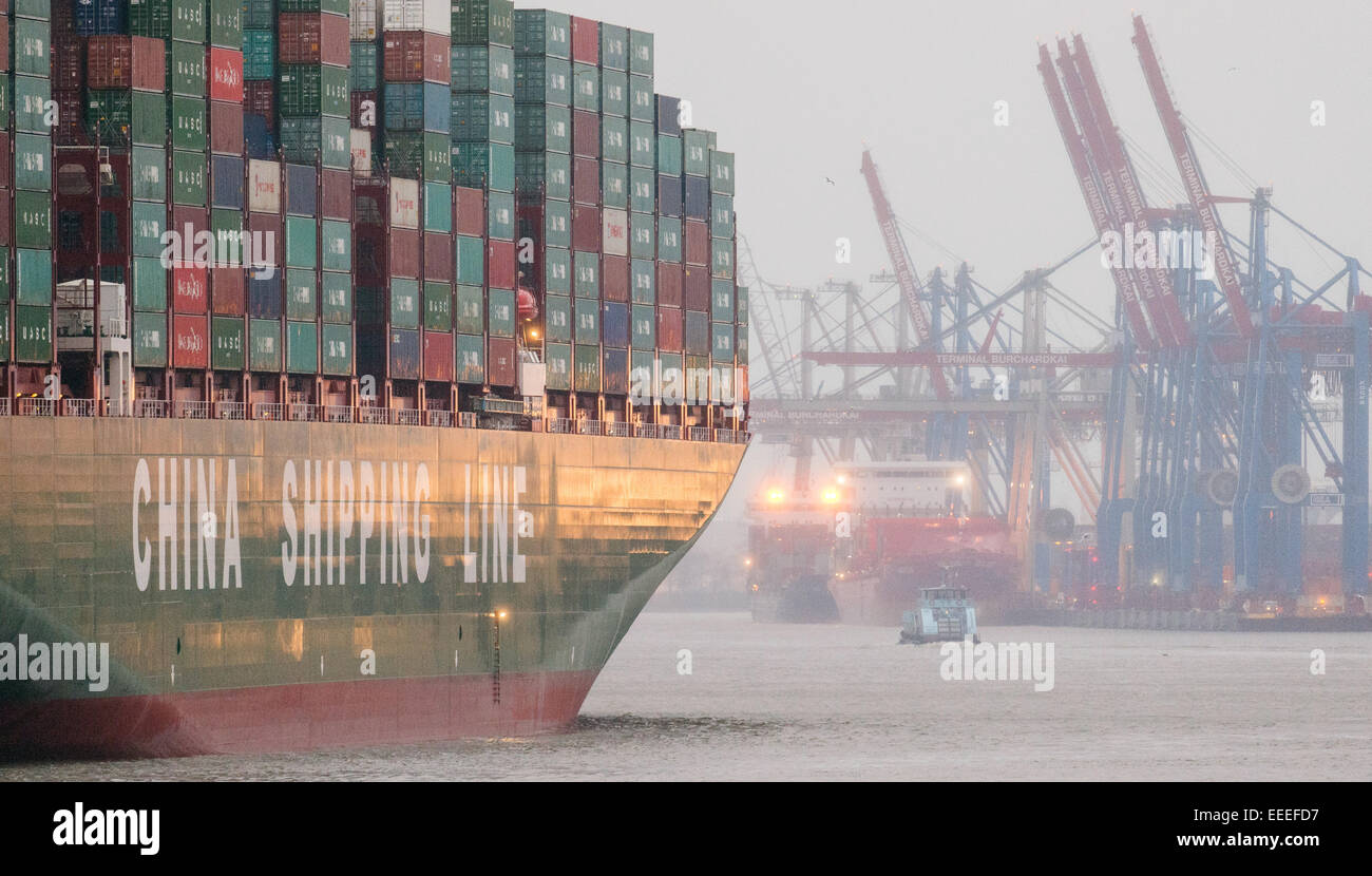 The world's largest ship, the 'CSCL Globe' from the shipping company 'China Shipping Group' runs on 13 January 2015 accompanied by tugs in the harbor in Hamburg. Stock Photo