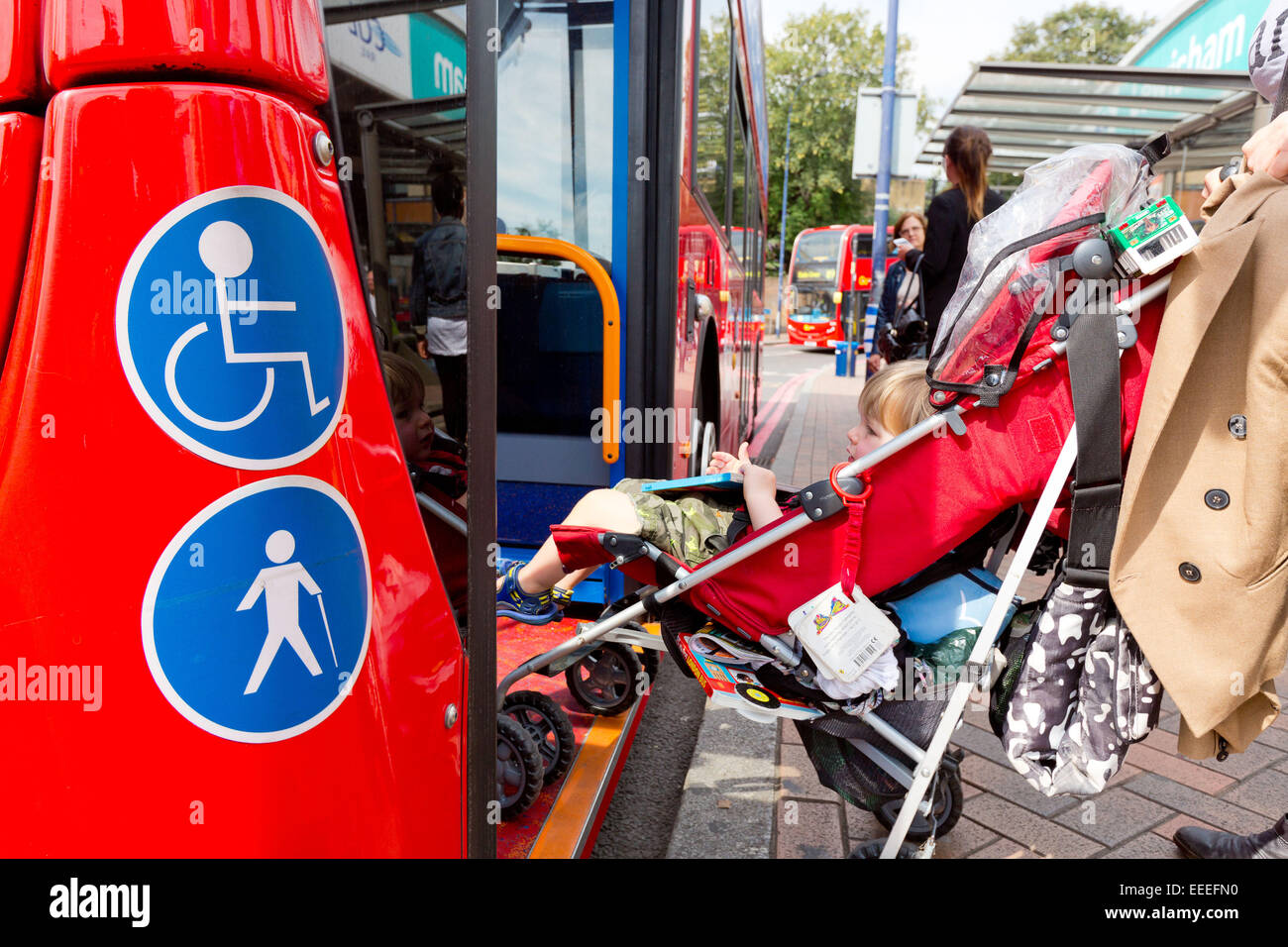 Accessibility signs with a woman boarding a bus with a buggey Stock Photo