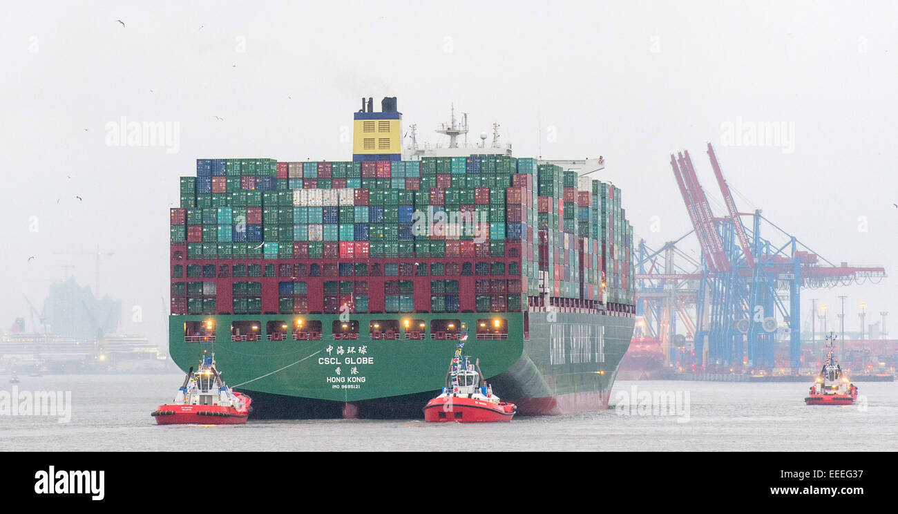 The world's largest ship, the 'CSCL Globe' from the shipping company 'China Shipping Group' runs on 13 January 2015 accompanied by tugs in the harbor in Hamburg. Stock Photo