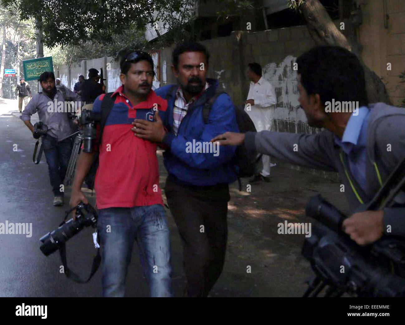 Injured AFP (Agence France-Presse) photo journalist Asif Hassan is leading to hospital while he has a lung punctured injury after gunshot during protest coverage near French Embassy in Karachi on Friday, January 16, 2015. Numerous activists of Islami Jamiat-e-Tulba hold a protest against publication of blasphemous caricatures in French Charlie Hebdo and moved ahead towards French Embassy whereas police used water cannon and tear gas shells to disperse aggressive protesters turn into a ferocious clash. Stock Photo