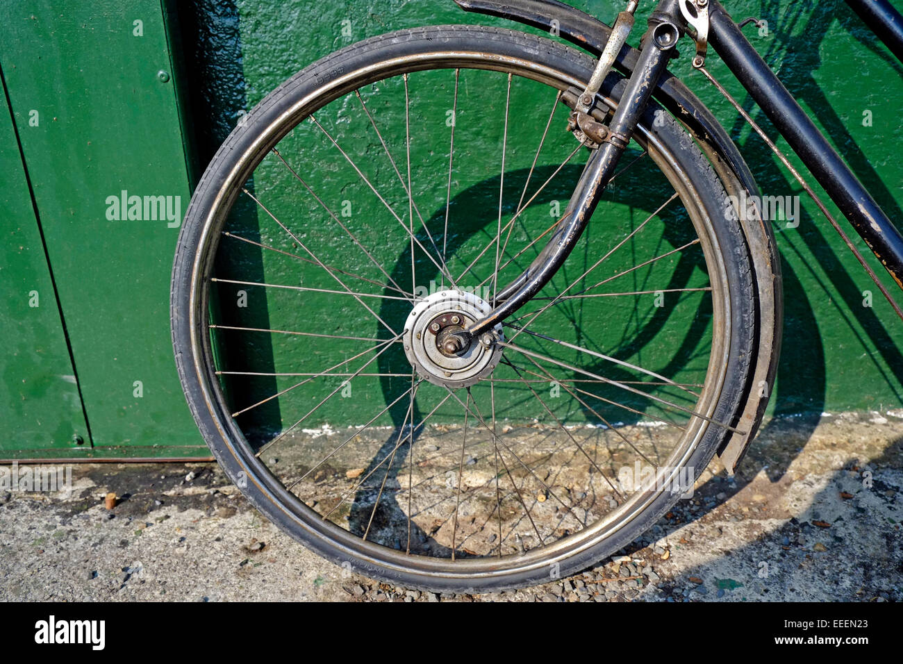 Vintage Bicycle Wheel close up parked at green shed Stock Photo